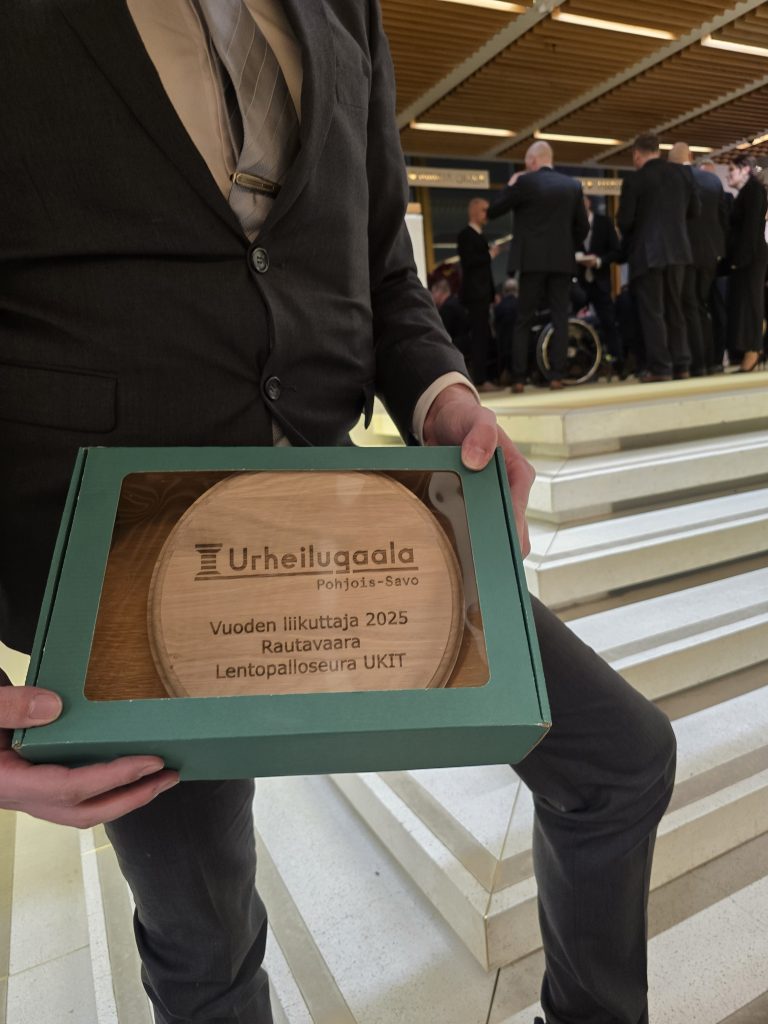 Kuvassa lähikuva palkintolaatasta. Palkintolaatassa lukee Urheilugaala Pohjois-Savo, Vuoden liikuttaja 2025, Rautavaara, Lentopalloseura UKIT.