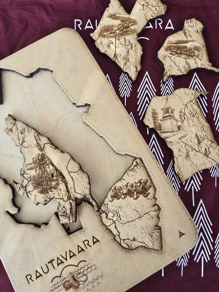 Kuvassa Rautavaaran kartan muotoinen puinen palapeli. Pelistä on irrotettu kolme palaa.