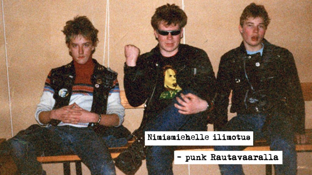 Kuvassa kolme nuorta miestä pukeutuneena punkkarimaisiin asuihin. Oikeassa alareunassa teksti Nimismiehelle ilimotus - punk Rautavaaralla.