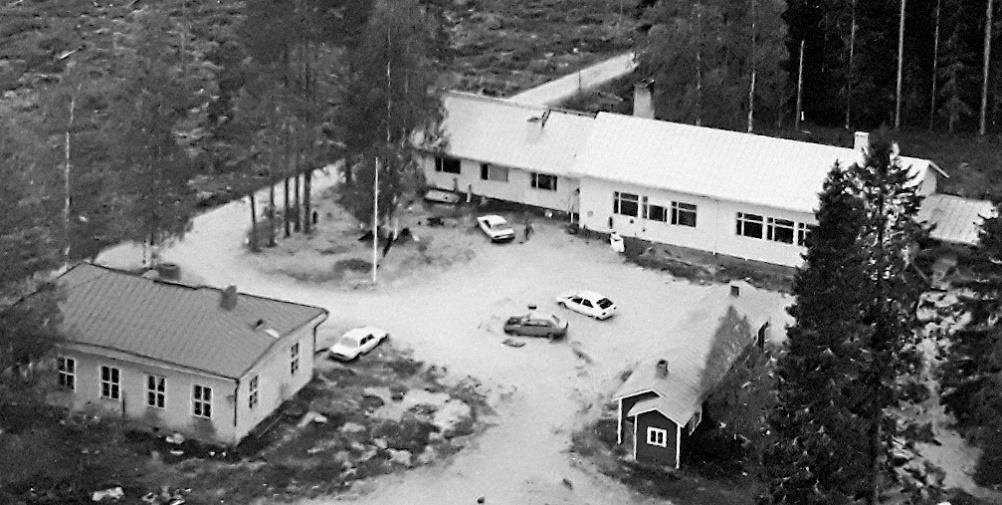 Yläilmakuva, jossa Lehtovaaran uusi ja vanha koulu. Pihalla on neljä autoa.