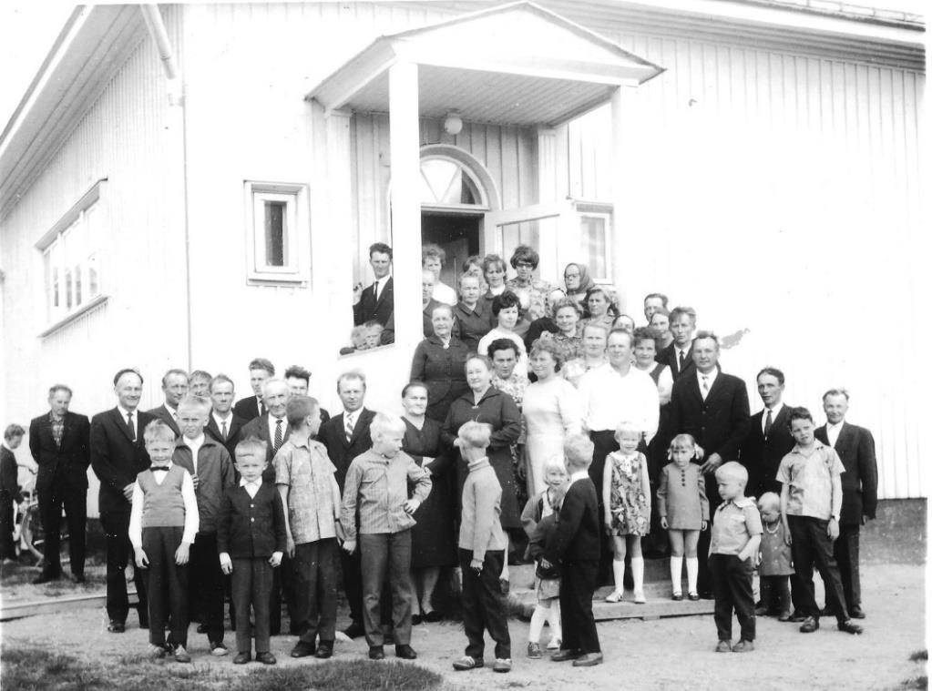 Kuvassa ihmisiä Rannankylän koulun edessä. Kuvassa vietetään koulun lakkautusjuhlaa vuonna 1968.