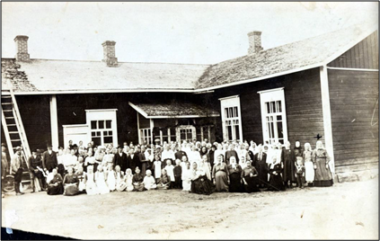 Kuvassa paljon ihmisiä Suojärven koulun edustalla.