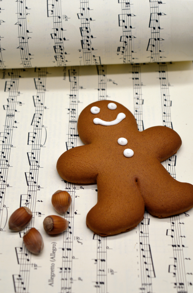 Kuvassa auki oleva lauluvihko nuotteineen. Päällä makaa pipariukko ja pähkinöitä koristeena.